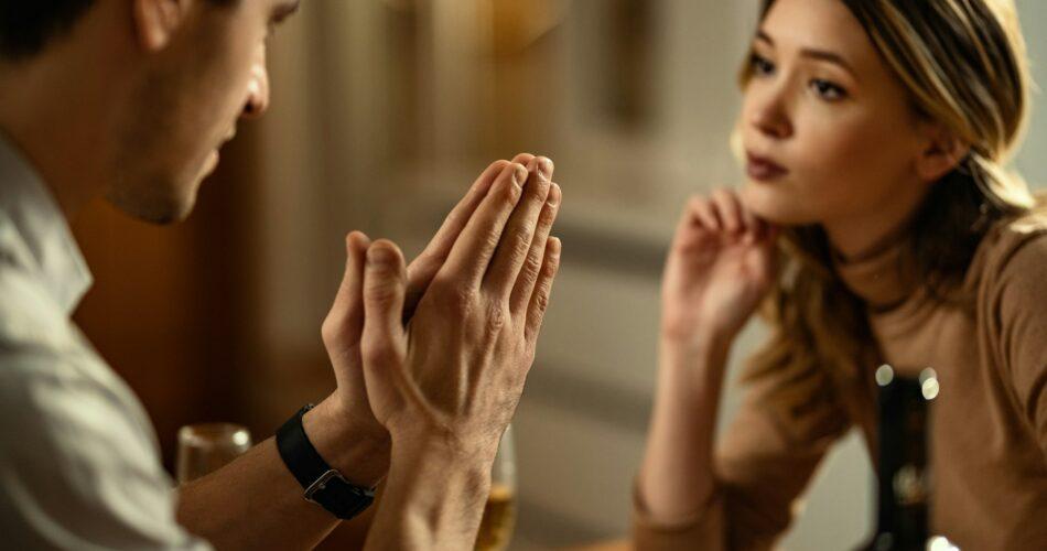 Close-up of man begging his girlfriend for forgiveness.