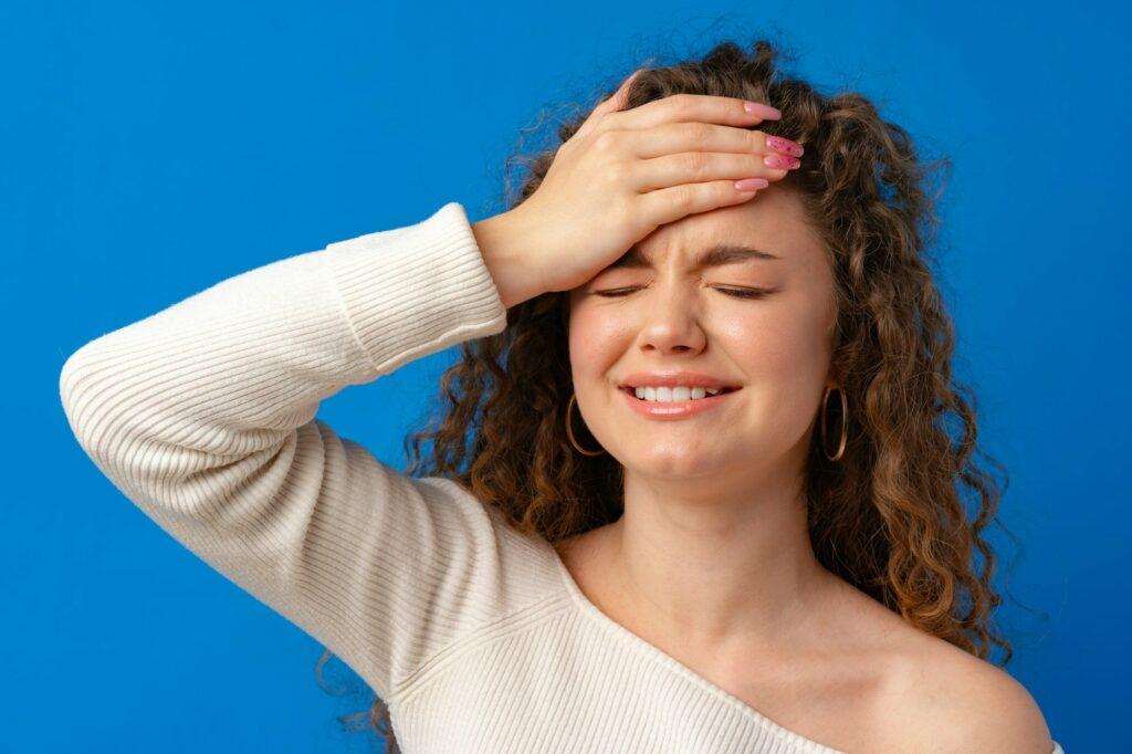 Concerned, stressed, regretful young woman holding her head