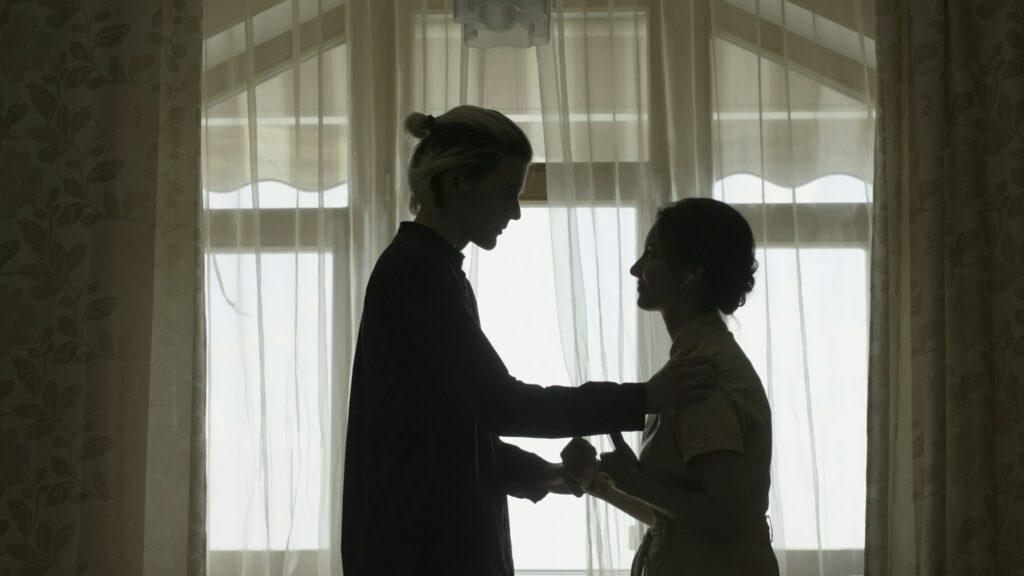 Couple is discussing something at window. Stock. Young man confesses his love to woman at window