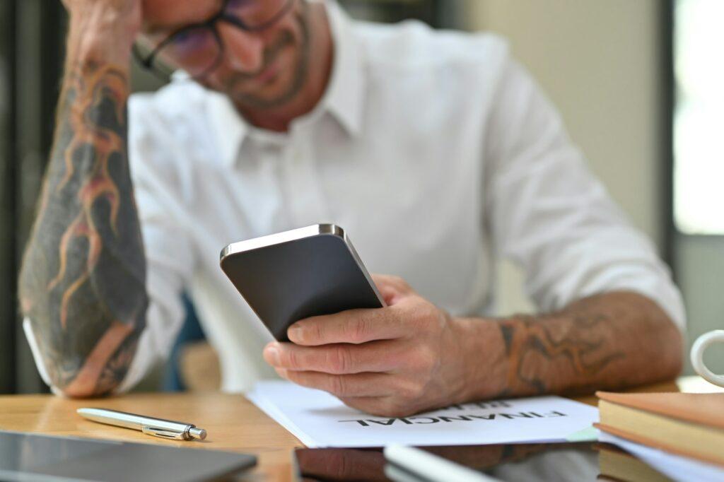 Frustrated man reading bad news smart phone or having problem at work.